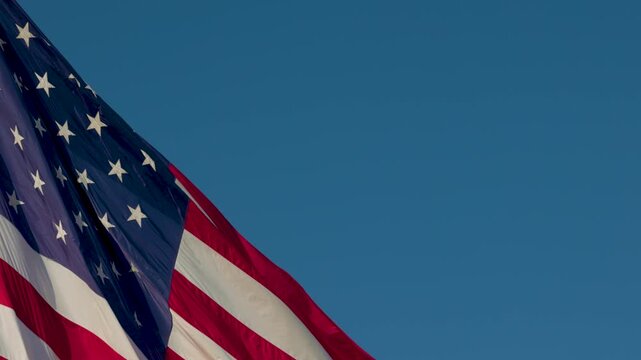 Close-Up Seamless Loop of American Flag Waving with Copy Space Against Blue Sky