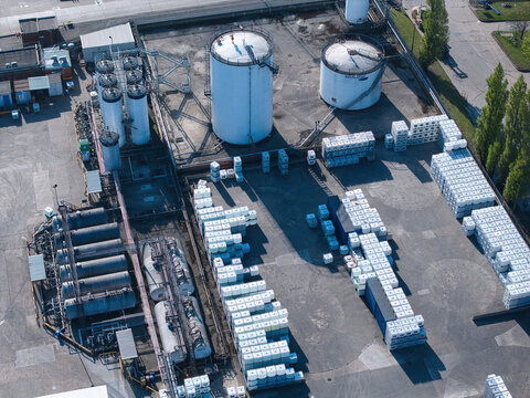 Aerial view of PD Ports industrial facility featuring large white storage tanks and rows of stacked containers on an asphalt lot in Scunthorpe, England, United Kingdom.