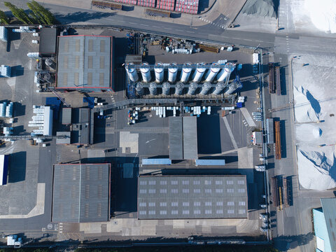 Aerial view of PD Ports industrial facility featuring storage silos, large warehouses, and logistics yards under bright daylight in Scunthorpe, England, United Kingdom.