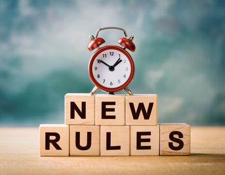 new rules concept with alarm clock on wooden blocks time for change policy updates