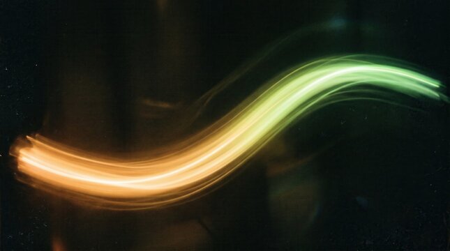 Dynamic glowing light trail wave with green and orange motion blur on dark background, perfect for technology presentations, website headers, and modern corporate branding