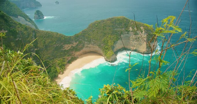 Breathtaking view of ocean waves at Kelingking Beach from high cliff edge in Bali Nusa Penida