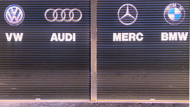 German car makers Volkswagen, Audi, Mercedes-Benz and BMW signs on mechanic workshop garage doors