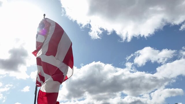 Close View of American Flag Flying in the Wind Against Sky