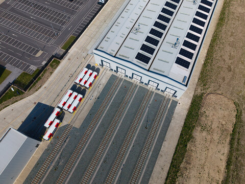 Aerial view of a modern train manufacturing facility with solar panels on the roof and train carriages parked on tracks in Goole, England, United Kingdom.