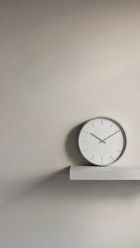 Minimalist wall clock metal material white tone matte surface vertical eye level shot