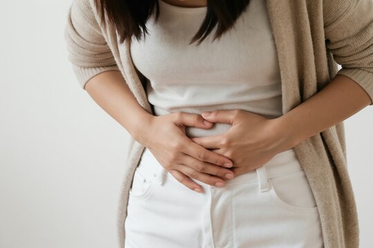 Woman clutches abdomen in pain. She suffers from urinary tract infection or bladder issues. Female experiences discomfort and stomach ache due to illness or medical condition. Healthcare concept.