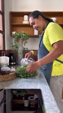Adult man is preparing spinach in a kitchen for making Indonesian east java traditional salad named pecel