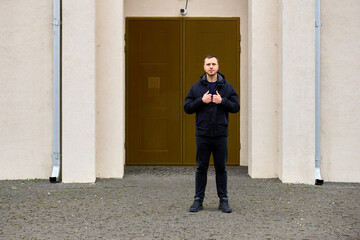 Fototapeta premium Man stands confidently in front of a sturdy, golden door
