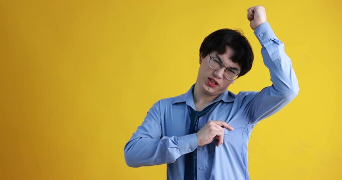 Young guy suffering from sweating on orange background