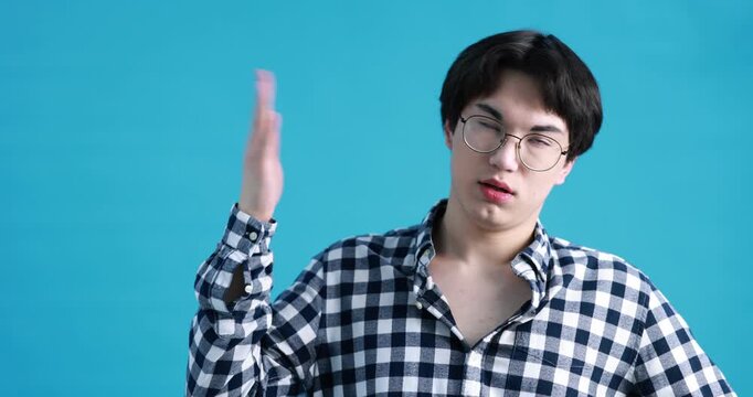 Young guy suffering from sweating on light blue background