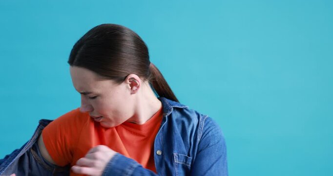 Woman suffering from sweating on light blue background