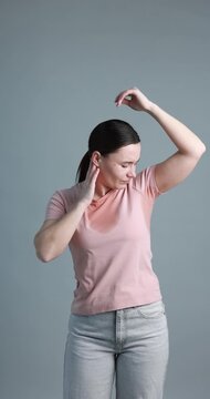 Woman suffering from sweating on grey background