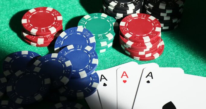 Casino chips and playing cards on green table