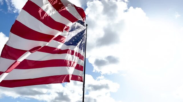 US American Flag Flying Against Dramatic Clouds and Bright Daylight