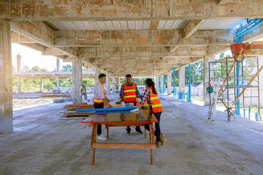 Structural engineer and architect and foreman worker with blueprints discuss, plan working for the building construction site office. Construction collaboration concept