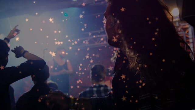 Stage lights and music urging man flipping hair, reacting to music with stars revealing keyboardist