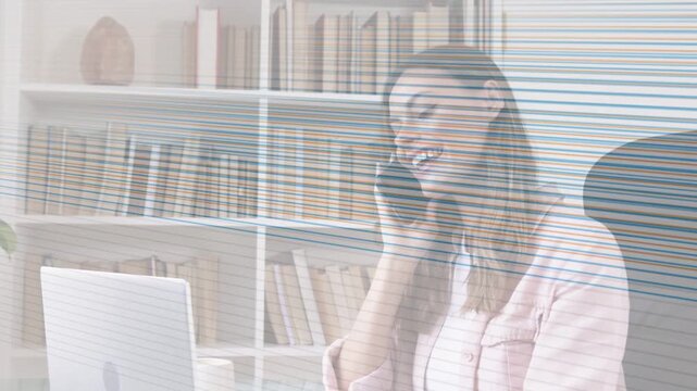 Vertical video: Answering ringing phone, woman using laptop at home wearing pink jacket, copy space