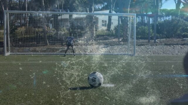 Female kicker running toward ball and striking in training drill, particles tracing shot path