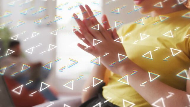 Woman stopping typing on laptop in tech work, clasping, reflecting as triangles floating over lap