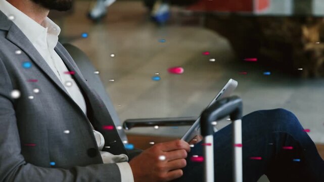 Man steadying tablet on suitcase handle, tapping while checking travel info, colored dots drifting