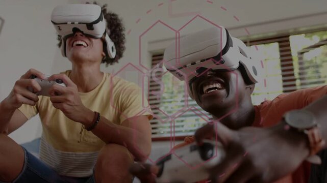Two men wearing white VR headsets pressing controllers on sofa, activating pink hex HUD and playing