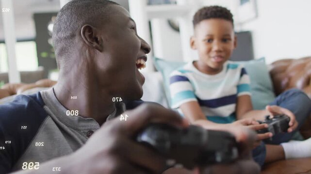 Dad pressing gamepad, laughing, turning to son as digits floating between them, sparking gaming fun