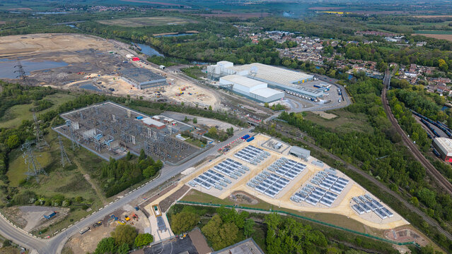 Aerial view of Battery Energy Storage Systems and an electrical substation near industrial buildings and a river in Knottingley, England, United Kingdom.