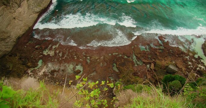 Ocean waves crash against coral reef shore at Diamond Beach in Nusa Penida island Bali