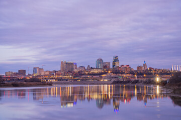 Naklejka premium The skyline of Minneapolis glows at dusk over the Mississippi River.