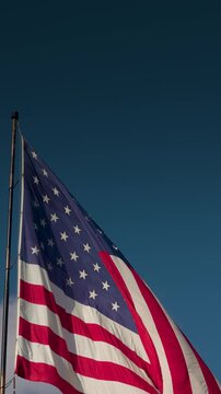 Vertical American Flag Waving In The Wind with Copy Space