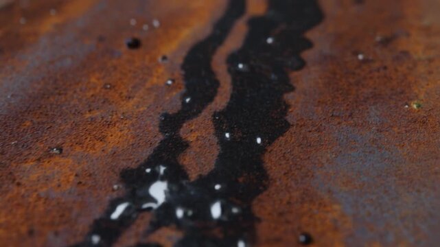 Oil droplets on rusty metal surface.