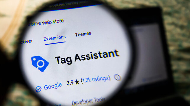 Closeup of a magnifying glass over a computer screen showing the google chrome web store page for the tag assistant browser extension