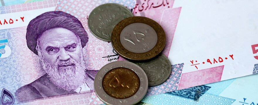 Iranian rial money bills and coins on table. Iran cash of IRR currency close up