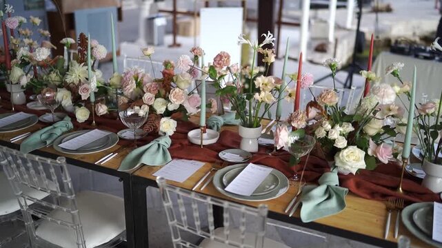 Contemporary rustic event table with floral arrangements and candle displays