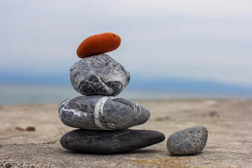 Fotobehang Rustgevend Pebble tower on the shore near the ocean in Japan. Red pebble on top. Cloudy morning.   © Keisergala
