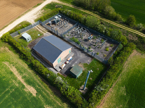 Aerial view of an electrical substation facility with a brick building and transformers surrounded by green fields Hampole, England, United Kingdom.