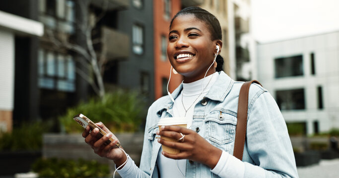 Walking, business and happy woman in city with earphones for music, travel and morning commute. Coffee, worker and African person with cellphone for streaming audio, podcast and playlist in town