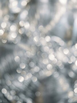 A blurred photograph captures a shimmering, sparkling effect, likely caused by light reflecting off of numerous small objects.