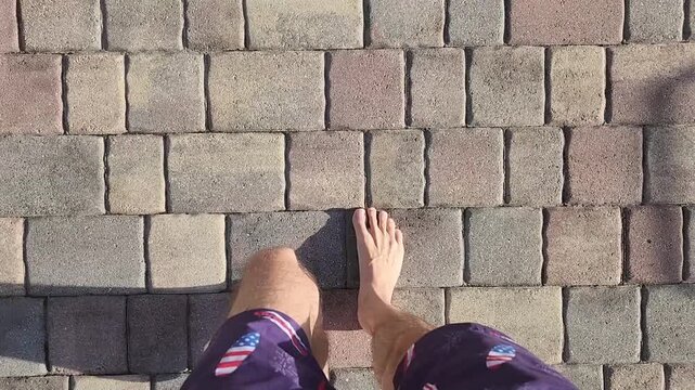 Barefoot Man Walking on Paving Stones Top View First Person Perspective