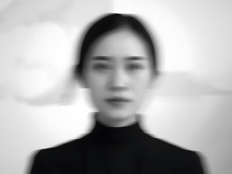 minimalist black and white portrait of young woman in soft focus monochrome lighting