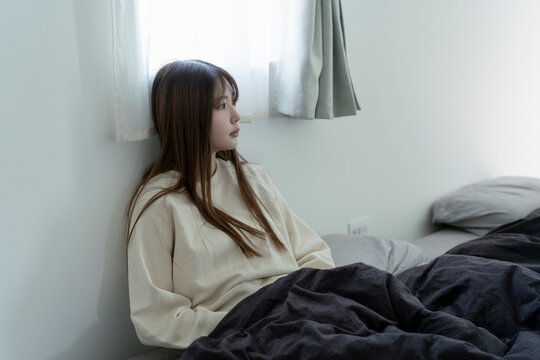 ベッドの上に座っている若い日本人女性