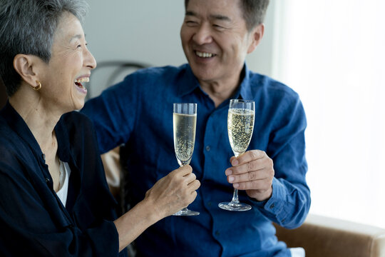 シャンパンで乾杯する日本人シニア夫婦