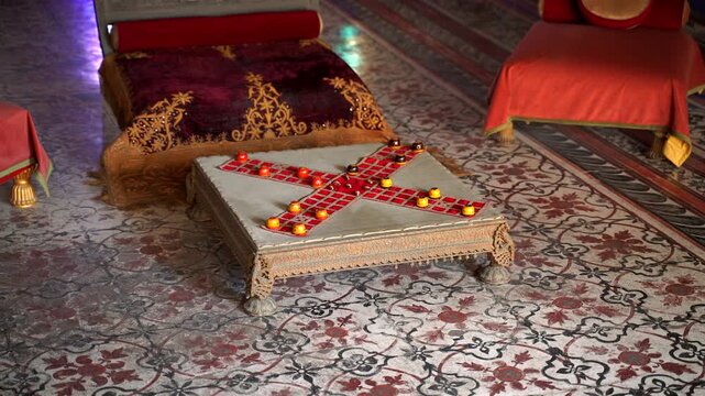 A static shot of a traditional Pachisi or Chaupar game board set on a low ornate table within a palace room, featuring cross-shaped fabric and yellow playing pieces, Jodhpur, India
