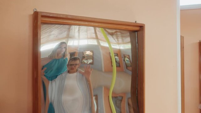 Distorted mirror reflections family weekend funhouse playful parents and child pose at warped glass exhibit in park attraction laughing and making silly faces candid bonding and joy captured in warm
