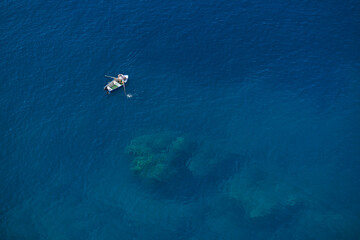 Obraz premium Minimal Blue Ocean Background with Small Boat and Copy Space
