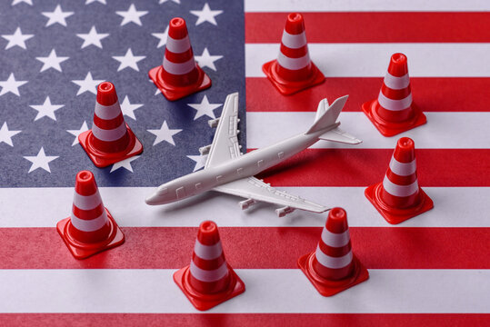 A mock up of airplane with no fly signs on a US flag as a concept for a flight ban