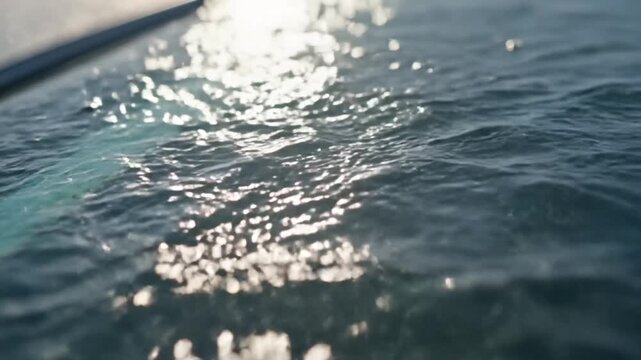 Waves washing over a car windshield creating abstract patterns of light and movement, showing the