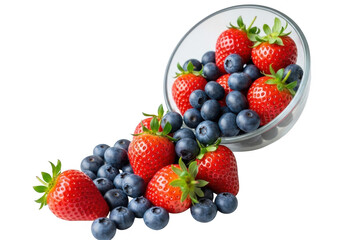 Obraz premium A glass bowl overflowing with fresh strawberries and blueberries, spilling onto a white surface isolated on transparent background