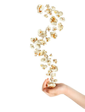 Floating fluffy popcorn above child's hand isolated on white background